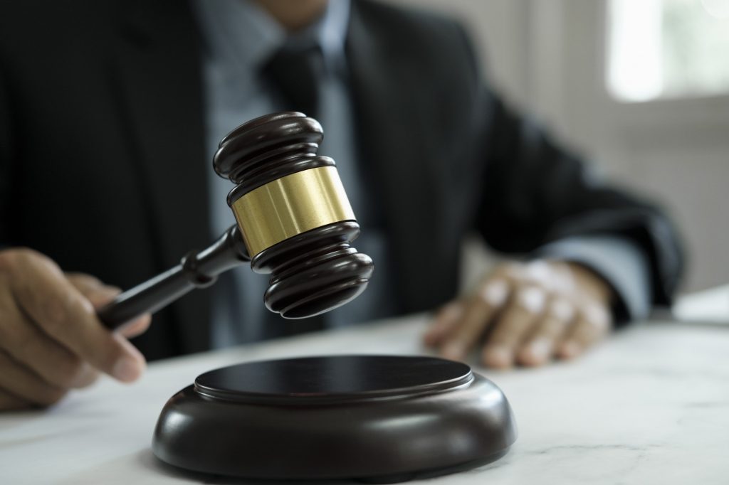 Male lawyer in the office with brass scale.